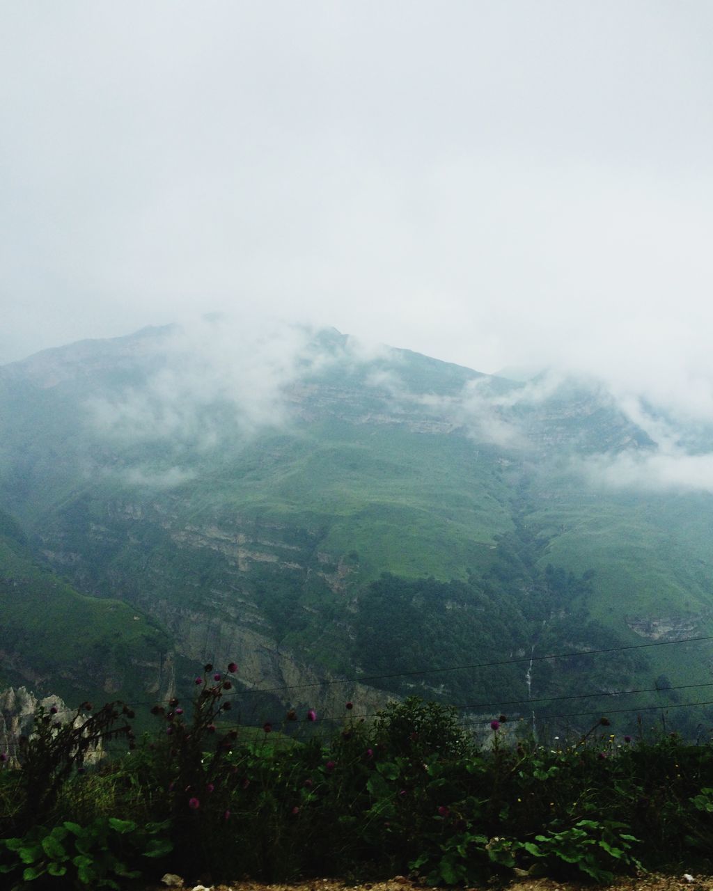 mountain, tranquil scene, scenics, tranquility, non-urban scene, landscape, beauty in nature, fog, tourism, mountain range, travel destinations, nature, physical geography, majestic, remote, geology, plant, day, sky, countryside, foggy, cloud - sky, solitude, vacations, outdoors, dreamlike, atmosphere, mist