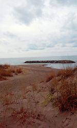 View of beach against cloudy sky