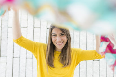 Portrait of smiling young woman holding fabric 