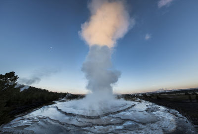 Majestic view of steam emitting from geyser at yellowstone national park against sky