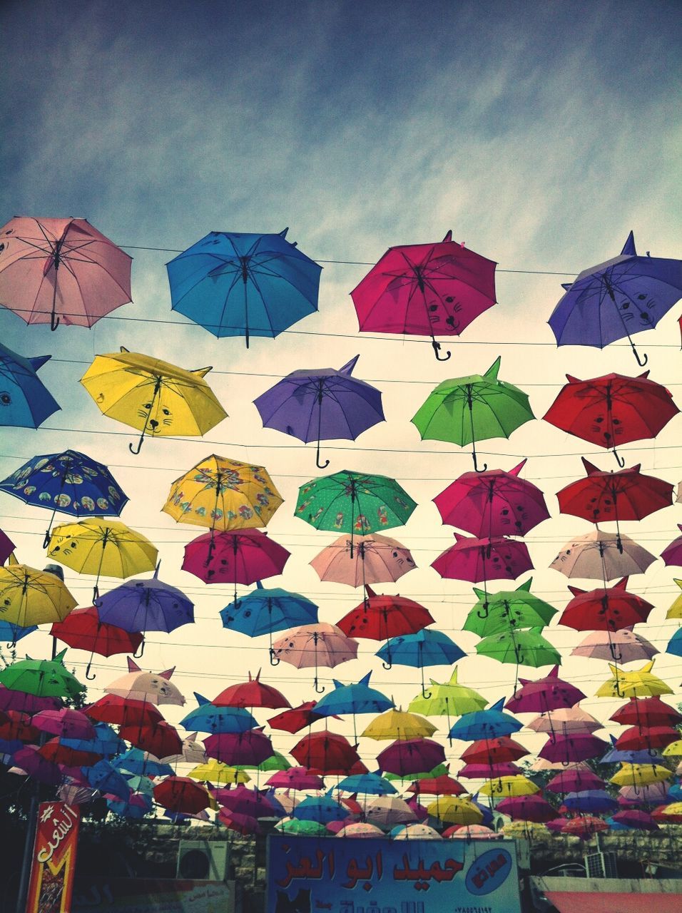 multi colored, low angle view, sky, umbrella, flag, decoration, hanging, day, colorful, built structure, pattern, architecture, design, variation, in a row, no people, art, outdoors, art and craft, creativity