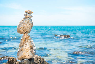 Zen stones balance at stony beach and sea background