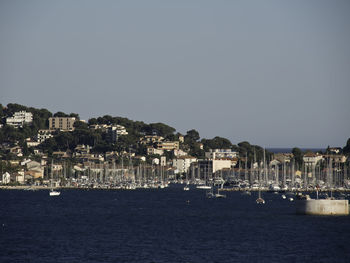 Scenic view of sea by town against clear sky