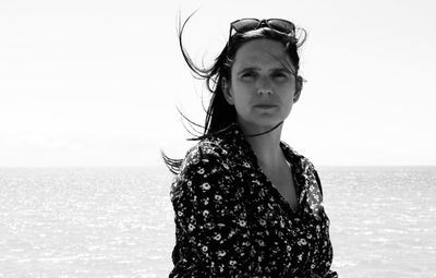 Portrait of woman standing at beach against sky