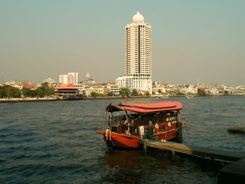 Ship in sea against buildings in city