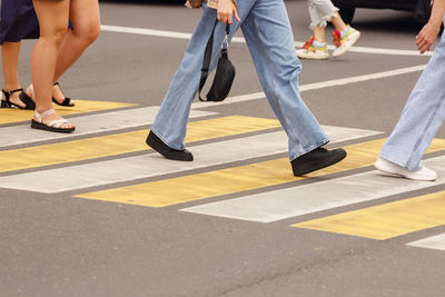 Low section of people walking on road