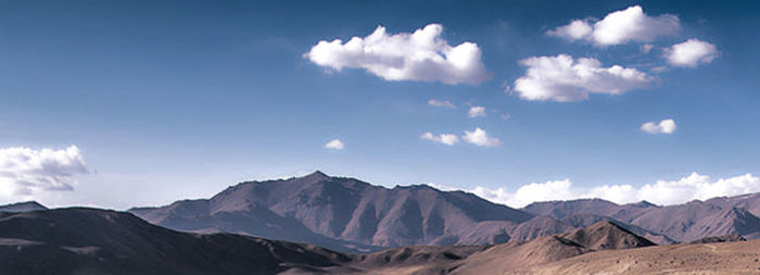 Panoramic view of mountains against cloudy sky