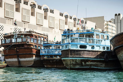 Boats moored in sea against buildings in city