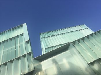 Low angle view of modern building against blue sky