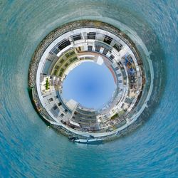 Directly below shot of swimming pool and buildings against sky