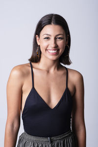 Beautiful young girl posing and smiling in a studio with a grey