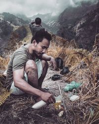 Man pouring drink during camping