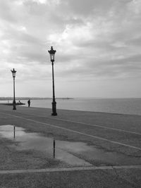 Pier on sea against cloudy sky