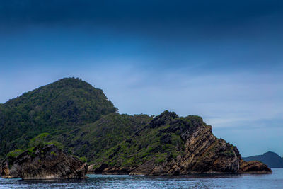 Scenic view of sea and mountains against blue sky