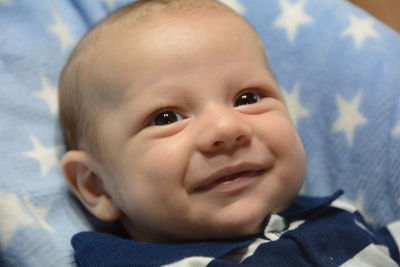 Portrait of cute baby boy on bed at home