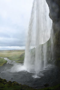 Scenic view of waterfall against sky