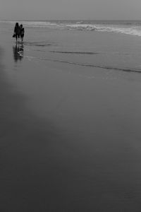 Reflection of man in sea against sky