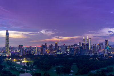 Illuminated buildings in city against sky