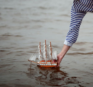 Woman putting boat on sea