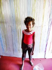 Portrait of girl standing against curtain