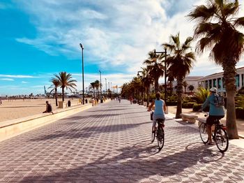 People riding bicycle on street in city