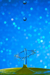 Low angle view of illuminated lighting equipment against blue sky