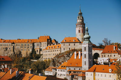 Buildings in city against clear blue sky