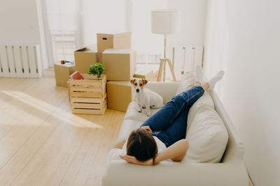 Full length of woman lying on sofa at home