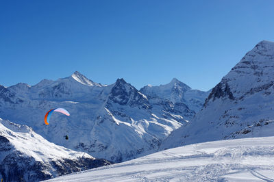 Scenic view of snowcapped mountains against clear blue sky