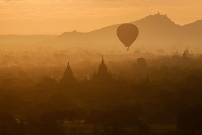 Silhouette hot air balloon flying during sunset