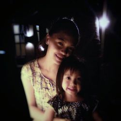 Portrait of happy mother with daughter at night