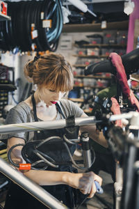 Mid adult mechanic repairing bicycle in workshop