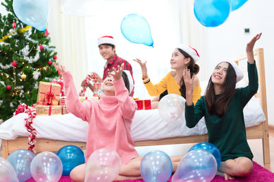 Friends playing with balloons at home during christmas