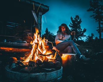 High angle view of woman sitting by bonfire