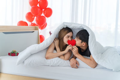 Midsection of couple lying on bed