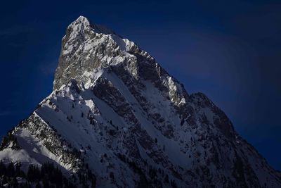 Low angle view of snowcapped mountain against sky