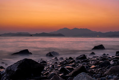 Scenic view of sea against orange sky