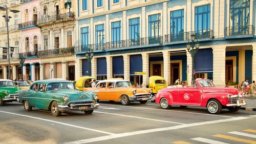 Cars on road by buildings in city