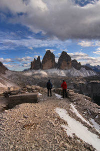 Rear view of people walking on mountain - tre cime di lavaredo - dolomiti - italy
