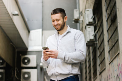 Young man using mobile phone outdoors