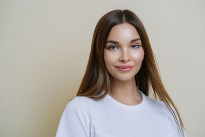 Portrait of young woman against white background