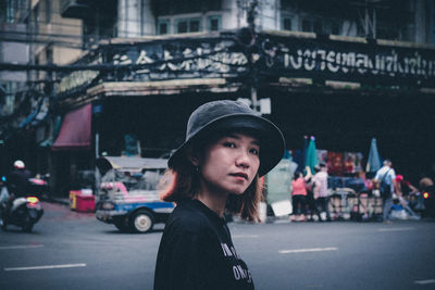 Portrait of young woman on street in city