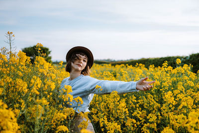 Portrait of woman standing amidst flowers