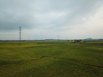 Electricity pylon on field against sky