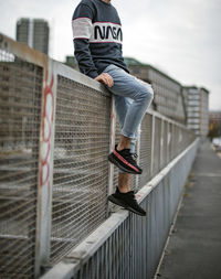 Low section of man standing on footbridge