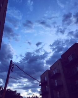 Low angle view of buildings against cloudy sky