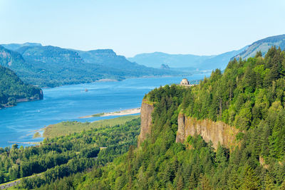 Scenic view of vista house on cliff by columbia river gorge against sky