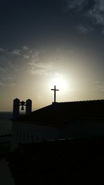 Silhouette of building against cloudy sky