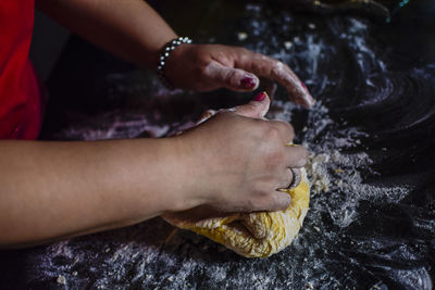 Close-up of woman kneading dough