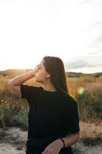 Teenager in sportswear and sunglasses watching the countryside sunset